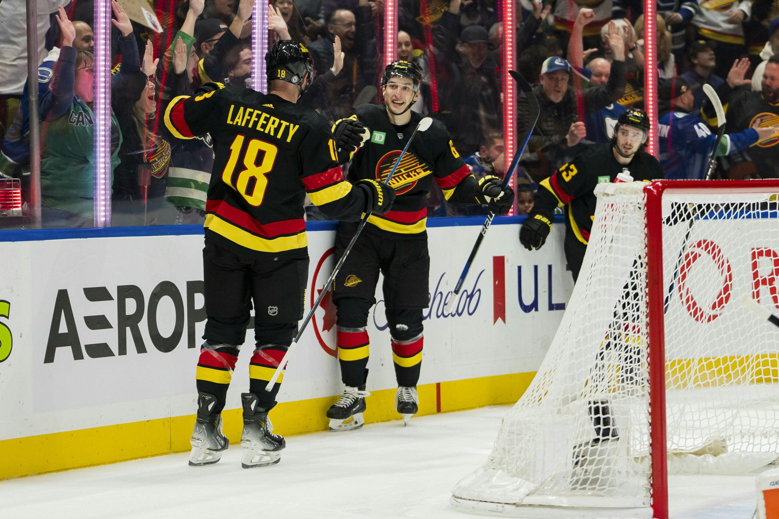 Ilya Mikheyev and Sam Lafferty of the Vancouver Canucks celebrate a goal.