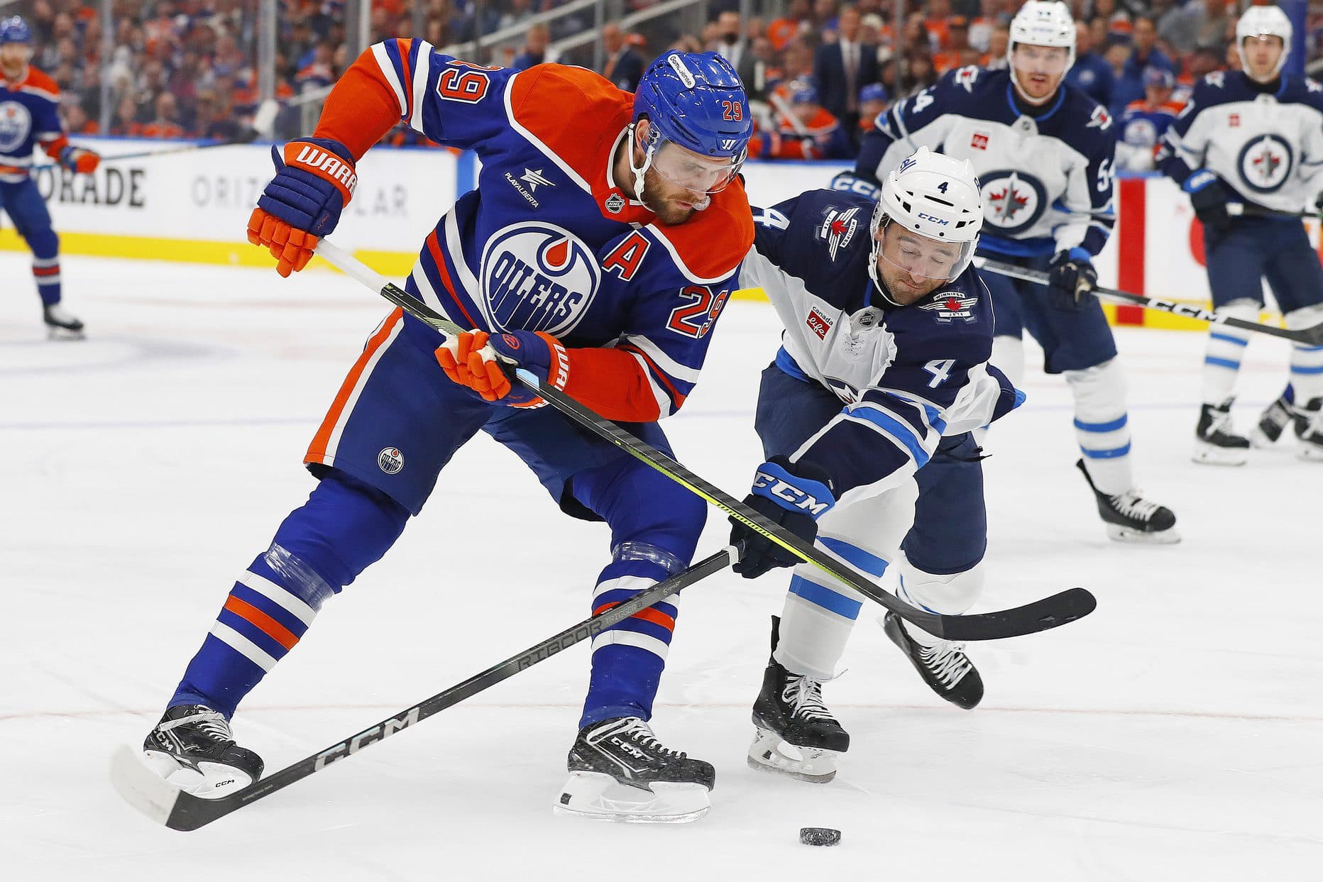 Edmonton Oilers forward Leon Draisaitl (29) and Winnipeg Jets defensemen Neal Pionk (4) battle for a loose puck during the first period at Rogers Place