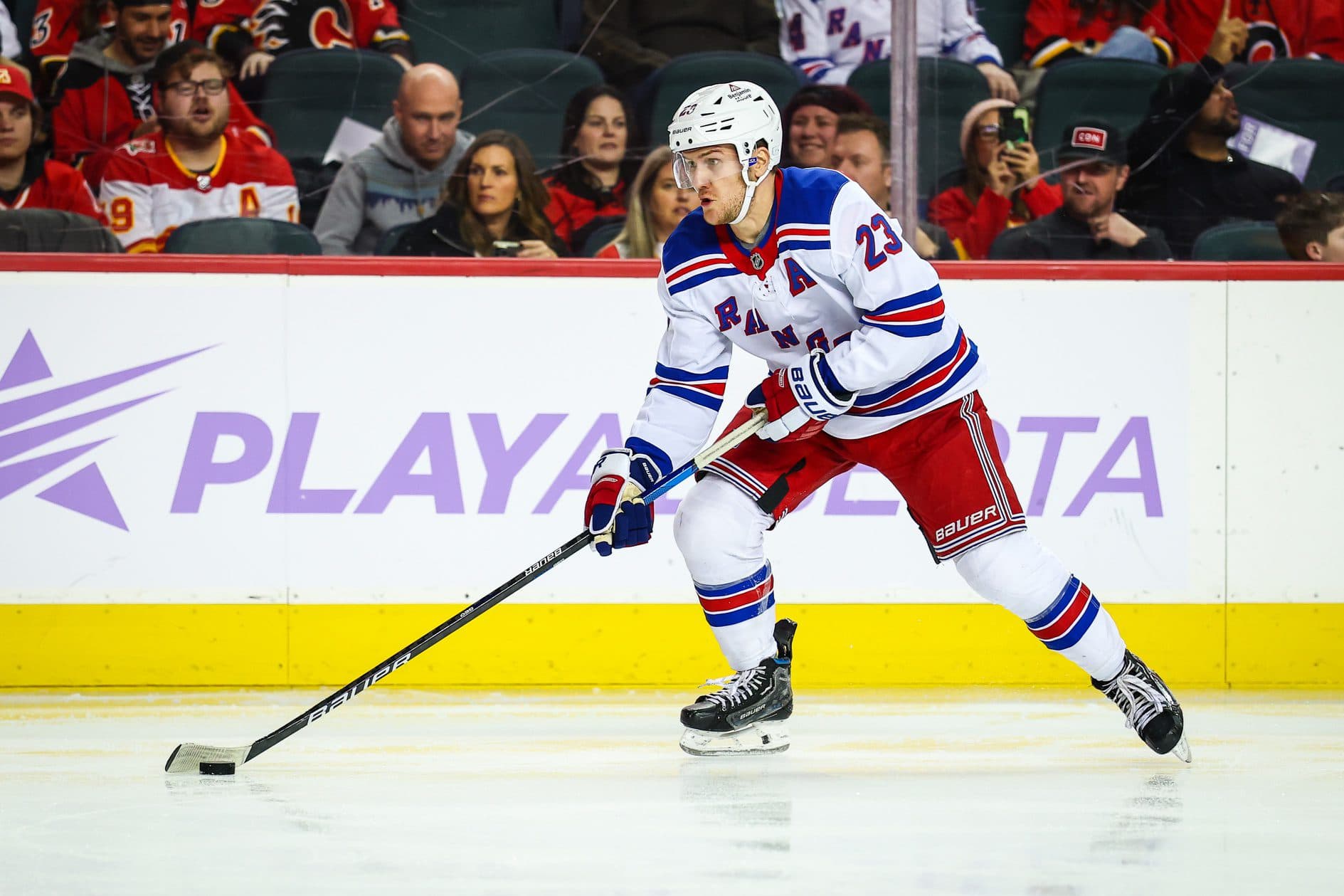 New York Rangers defenseman Adam Fox (23) controls the puck against the Calgary Flames during the third period at Scotiabank Saddledome