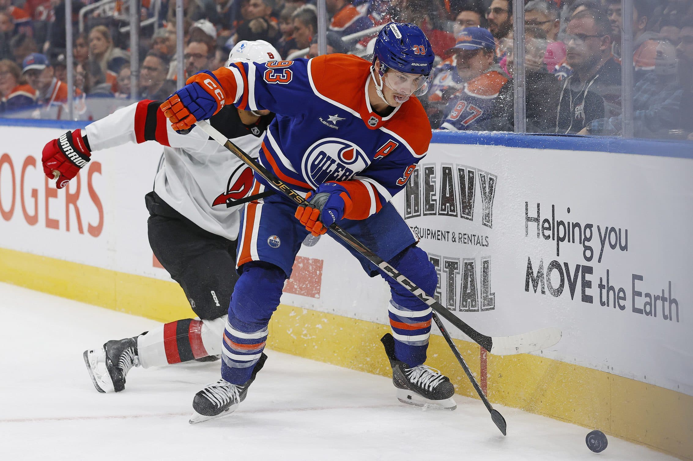 Edmonton Oilers forward Ryan Nugent-Hopkins (93) and New Jersey Devils defensemen John Kovacevic (8) battle along the boards for a loose puck during the third period at Rogers Place.