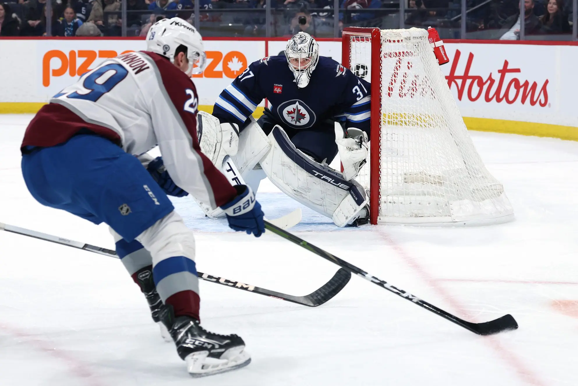 Colorado Avalanche center Nathan MacKinnon (29) gets set to shoot on Winnipeg Jets goaltender Connor Hellebuyck (37) during the first period at Canada Life Centre