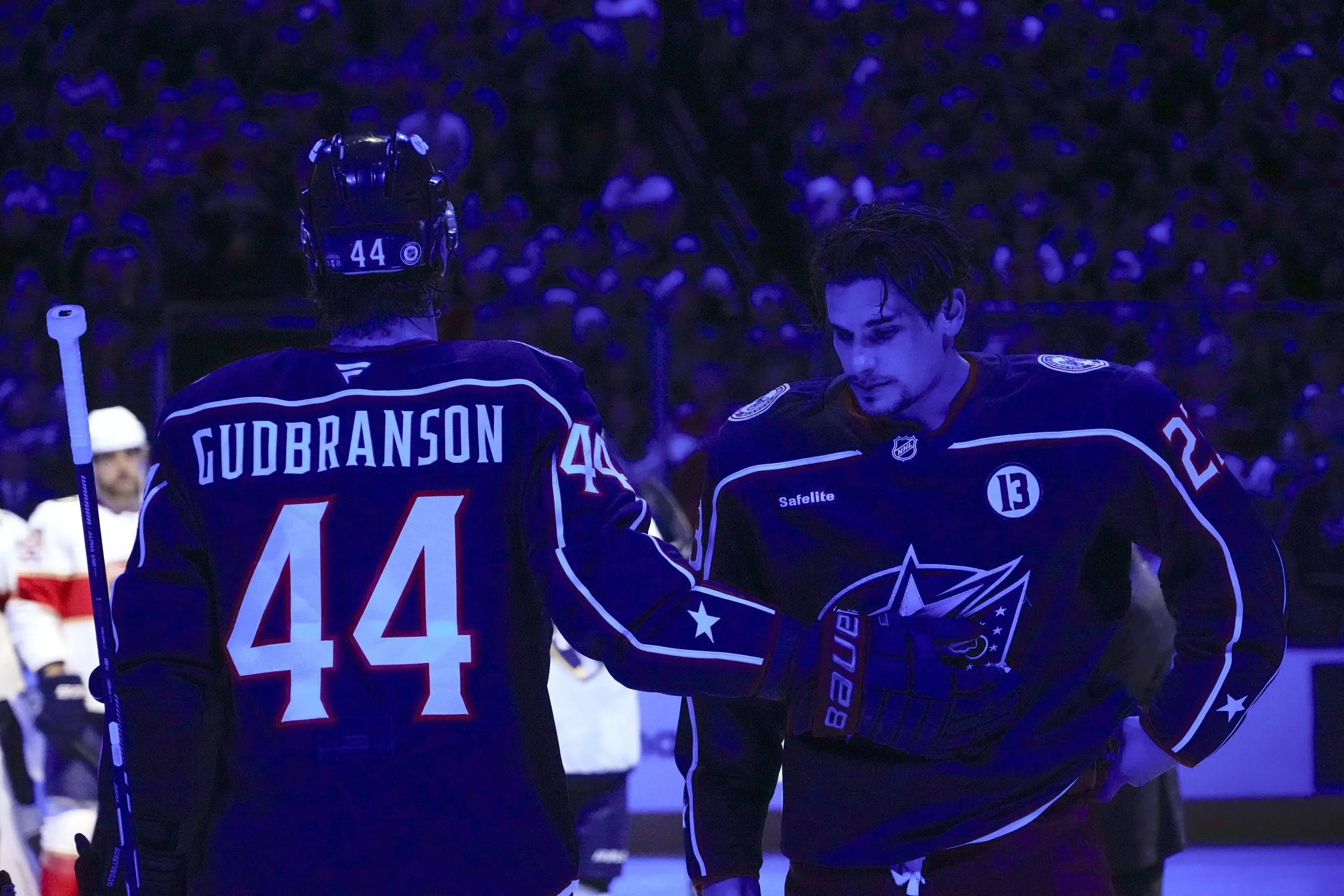 Columbus Blue Jackets defenseman Erik Gudbranson (44) taps Sean Monahan (23) after Monahan assisted with a memorial for Johnny Gaudreau before the home opener at Nationwide Arena.