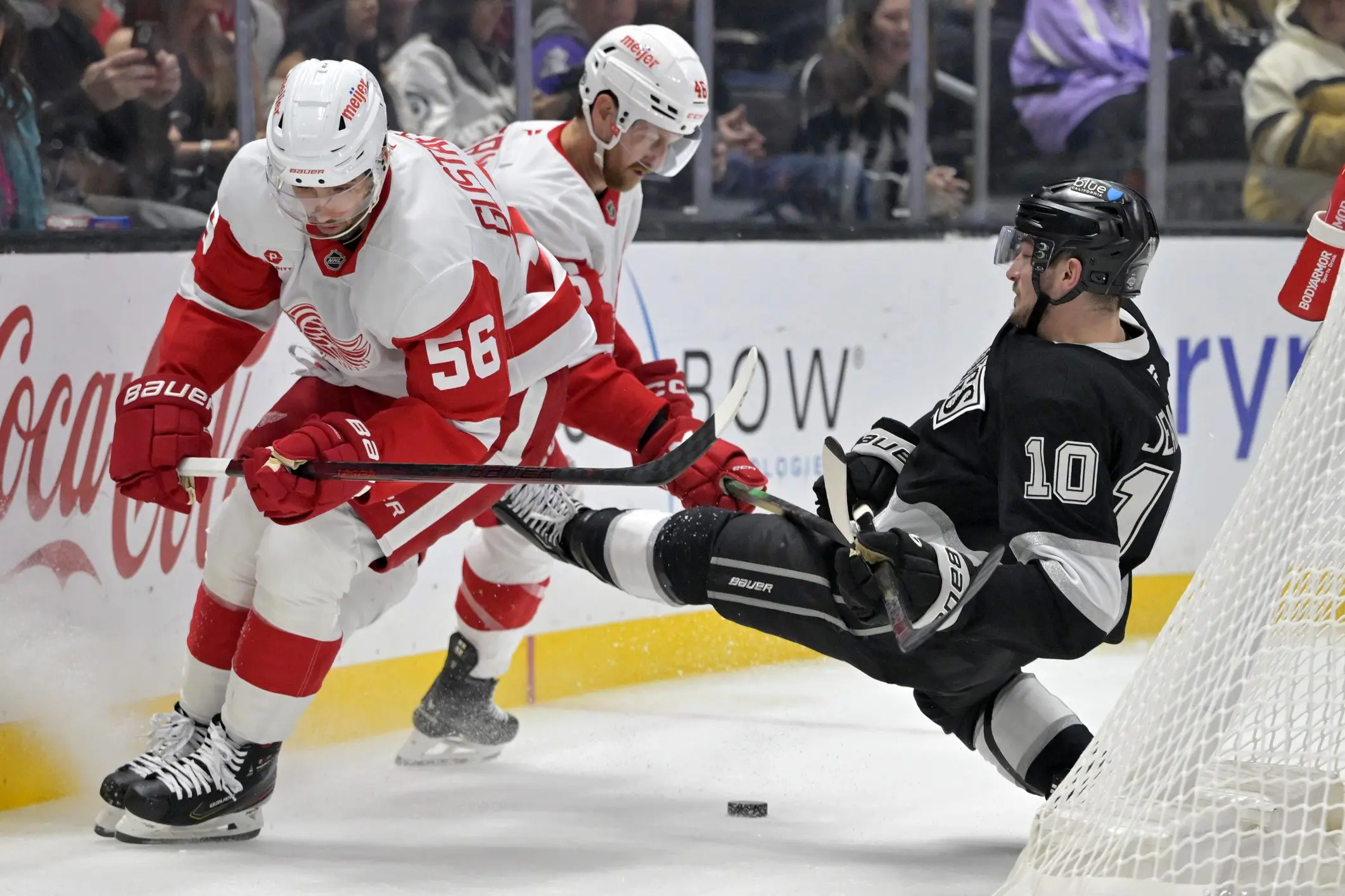 Los Angeles Kings left wing Tanner Jeannot (10) is checked by Detroit Red Wings defenseman Jeff Petry (46) as defenseman Erik Gustafsson (56) controls the puck in the second period at Crypto.com Arena.