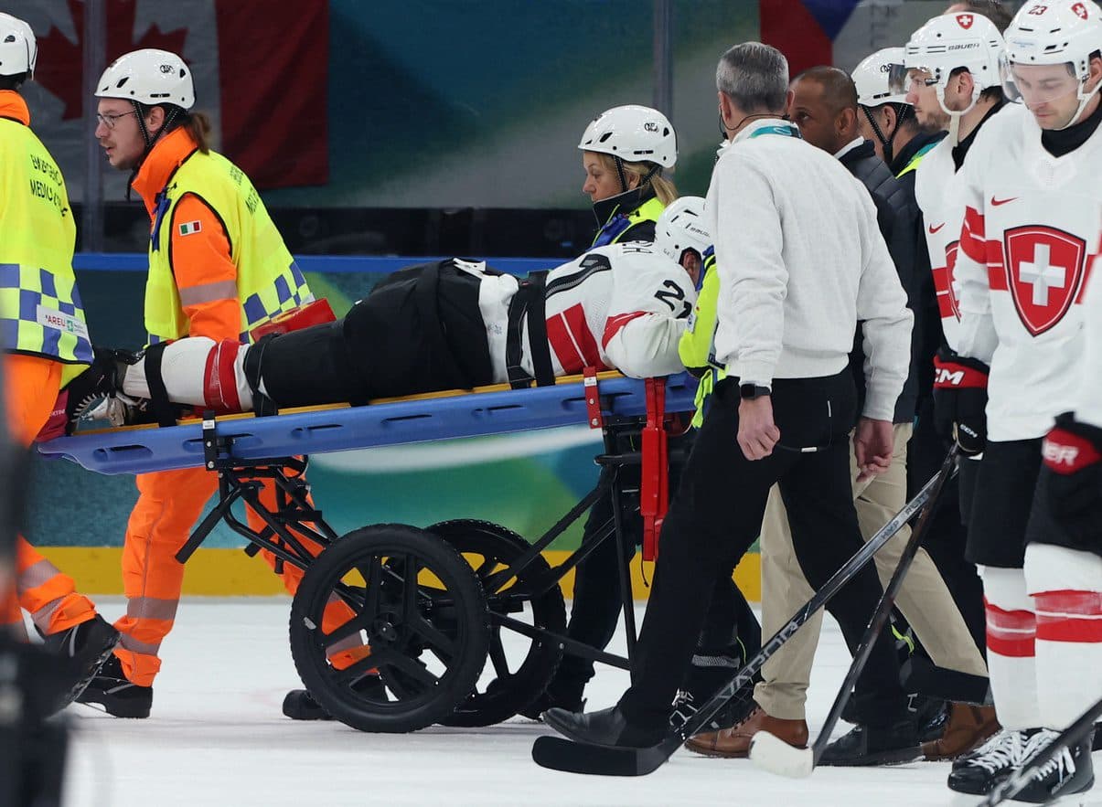 Kevin Fiala of Switzerland is taken off the ice by medical staff on a stretcher after sustaining an injury against Canada in men's ice hockey group A play during the Milano Cortina 2026 Olympic Winter Games at Milano Santagiulia Ice Hockey Arena.